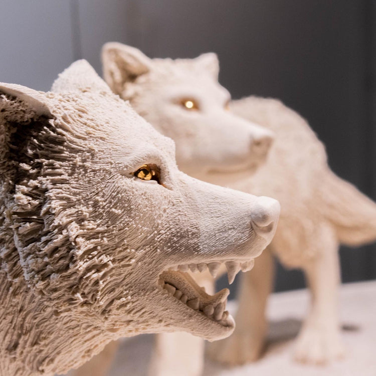 Close-up of two wolf statues with a blurred background