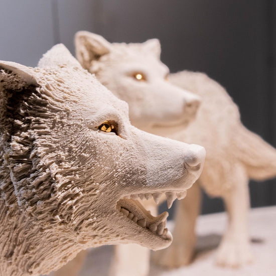Close-up of two wolf statues with a blurred background