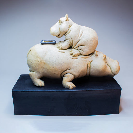 Decorative sculpture of two animals on a black base against a gray background